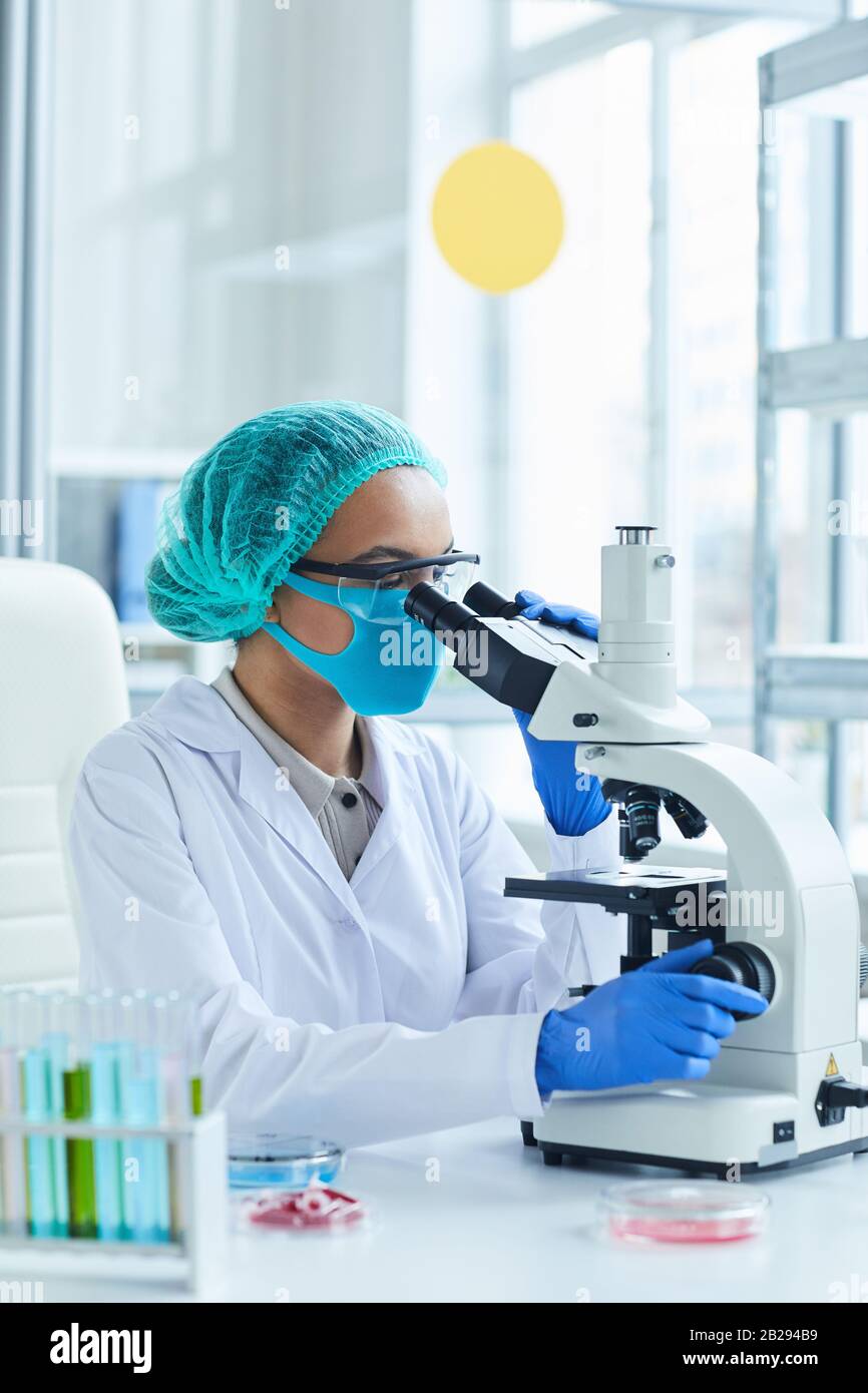 Portrait de la scientifique féminine regardant au microscope tout en travaillant sur la recherche en laboratoire médical Banque D'Images