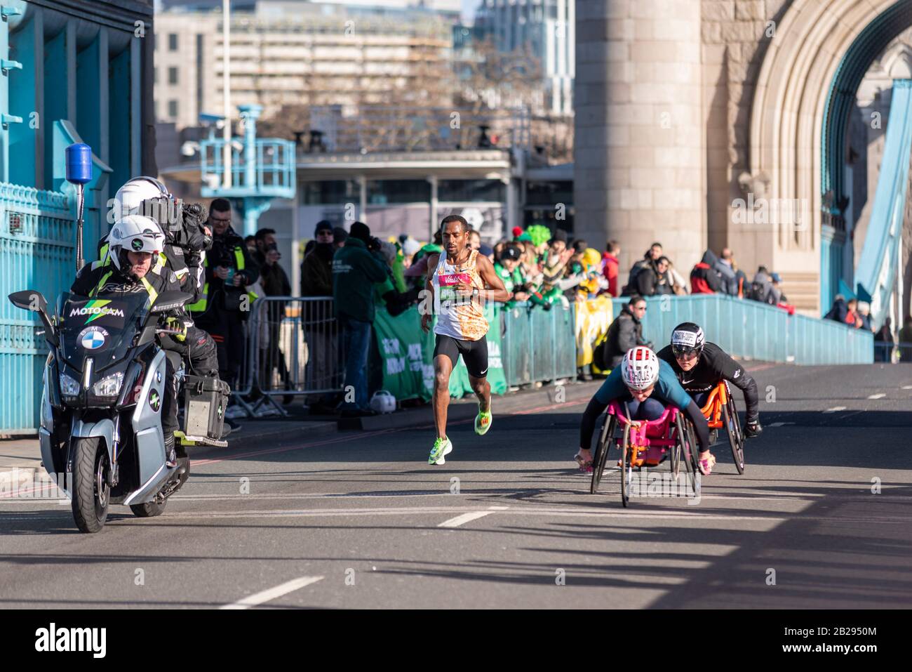 Kenenisa Bekele course dans le Vitality Big Half marathon croisant Tower Bridge, Londres, Royaume-Uni. Courir devant les athlètes en fauteuil roulant, derrière le vélo de télévision Banque D'Images