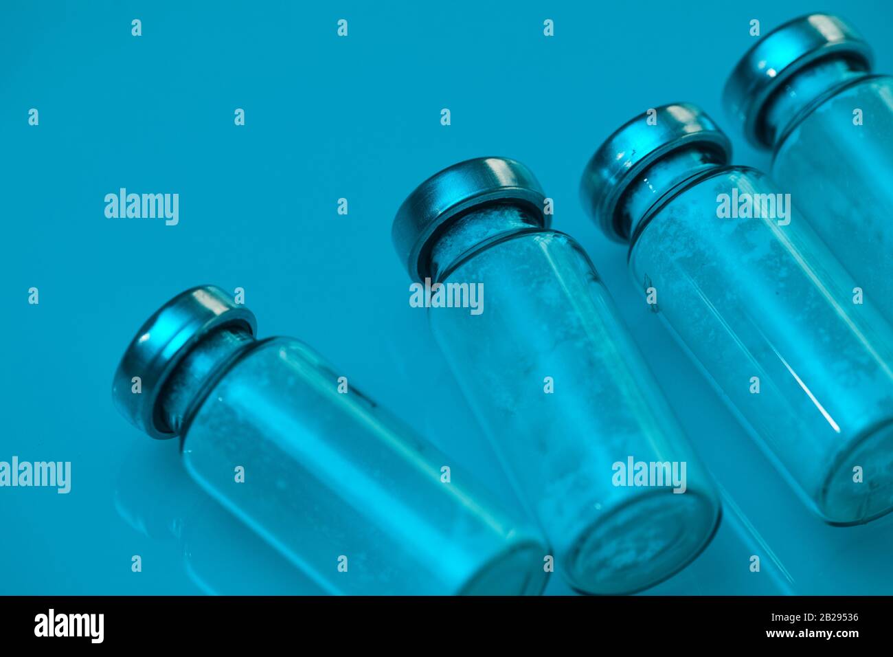 Gros plan des flacons en verre en ligne sur bleu dans un laboratoire médical, espace de copie Banque D'Images