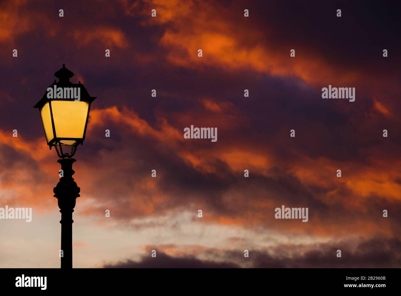 Lampe de rue à l'ancienne contre le beau ciel du coucher du soleil et les nuages colorés (avec espace de copie) Banque D'Images