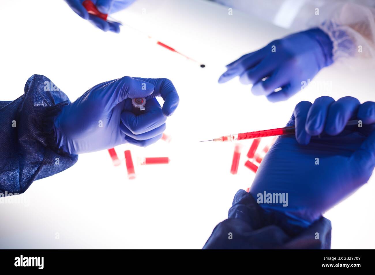 Gros plan de deux scientifiques examinant des échantillons de sang sur un panneau lumineux en laboratoire médical, espace de copie Banque D'Images