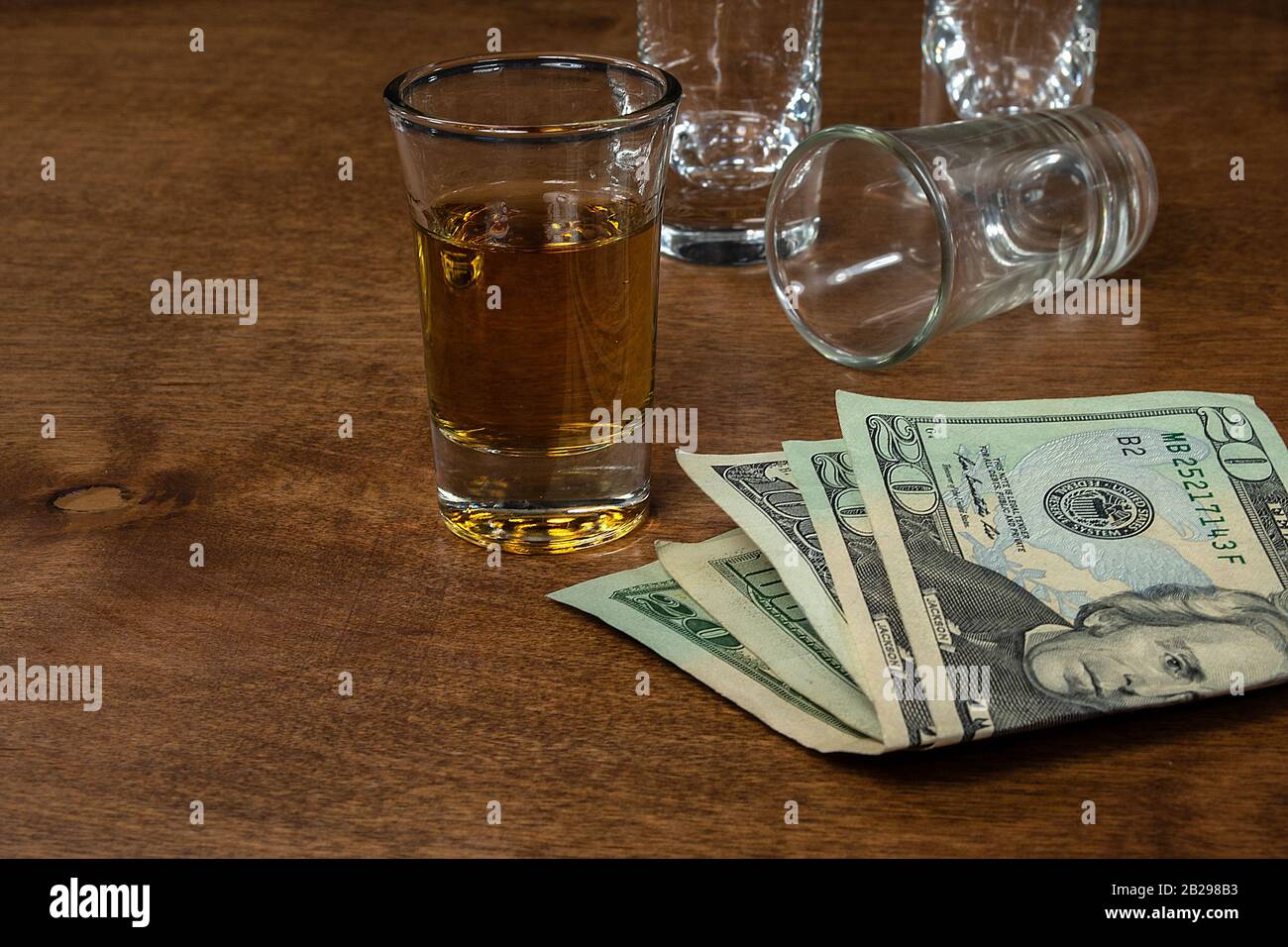Coup de whisky et verres de tir vides sur le bois avec de l'argent américain Banque D'Images