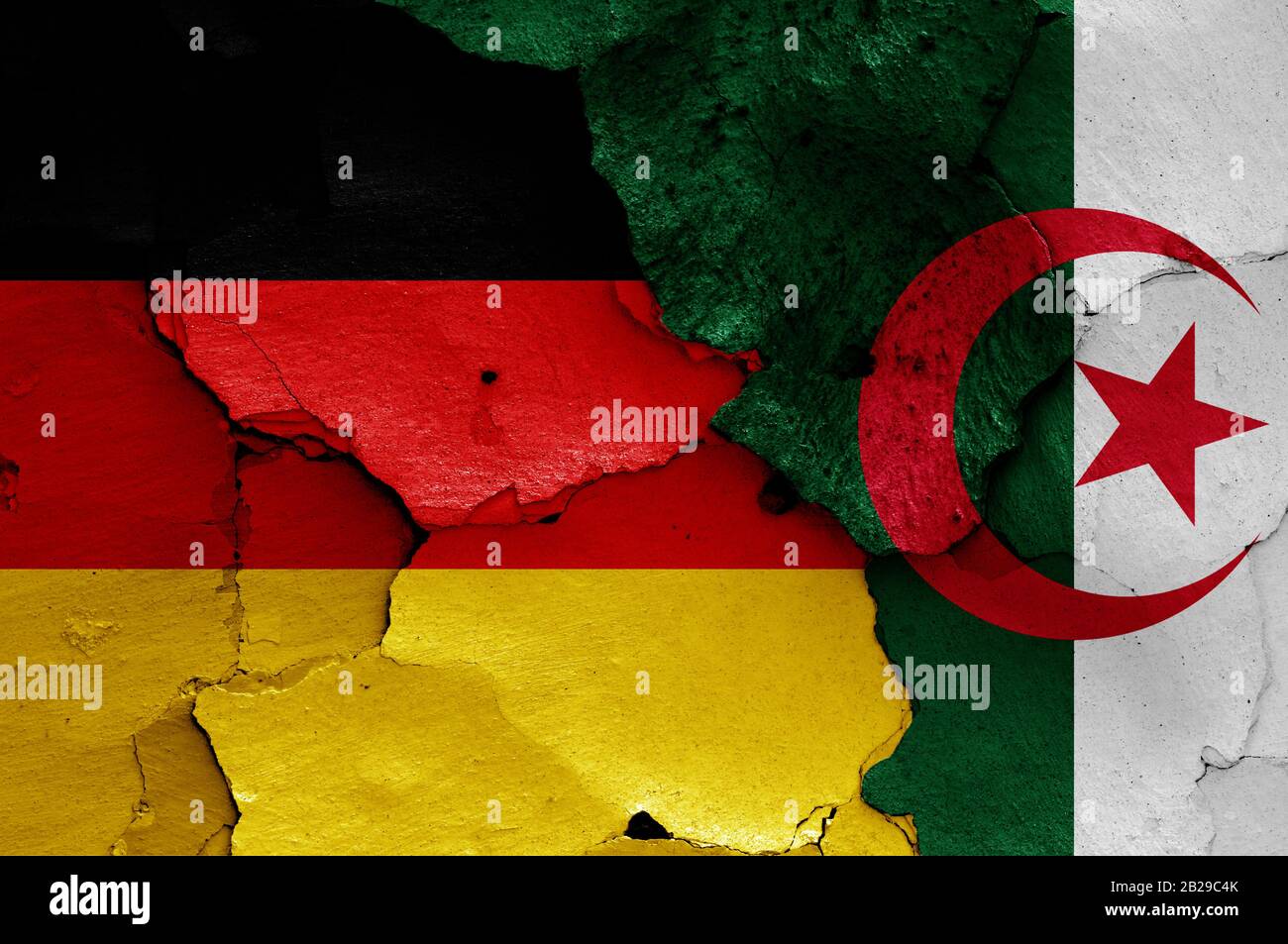 Drapeaux de l'Allemagne et de l'Algérie peints sur un mur fissuré Banque D'Images