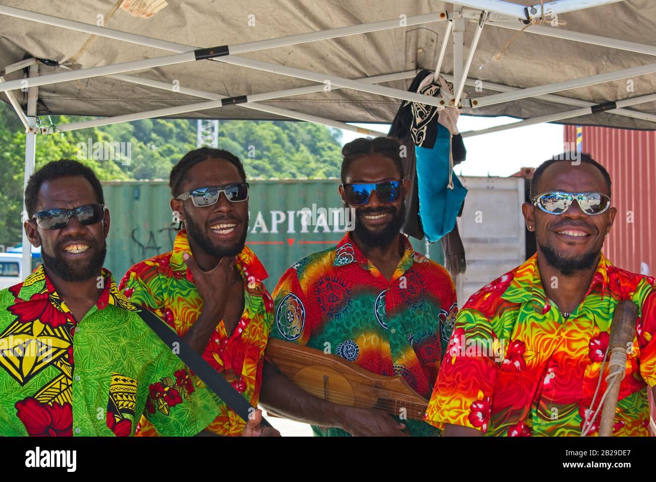 Port Vila, Vanuatu - 14 février 2020: Kanak hommes dans des chemises colorées chantant et posant pour les touristes. Banque D'Images