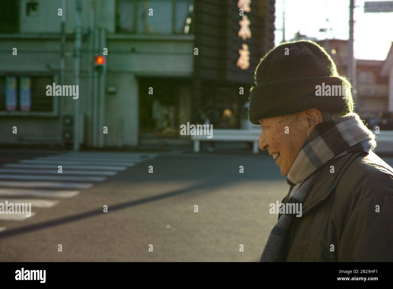 Un vieil homme asiatique marchant sur la route en hiver Banque D'Images