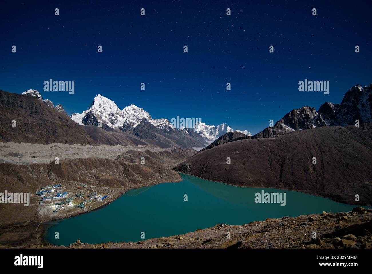 Vue nocturne sur le lac de Gokyo entouré de montagnes enneigées de l'Himalaya au Népal Banque D'Images