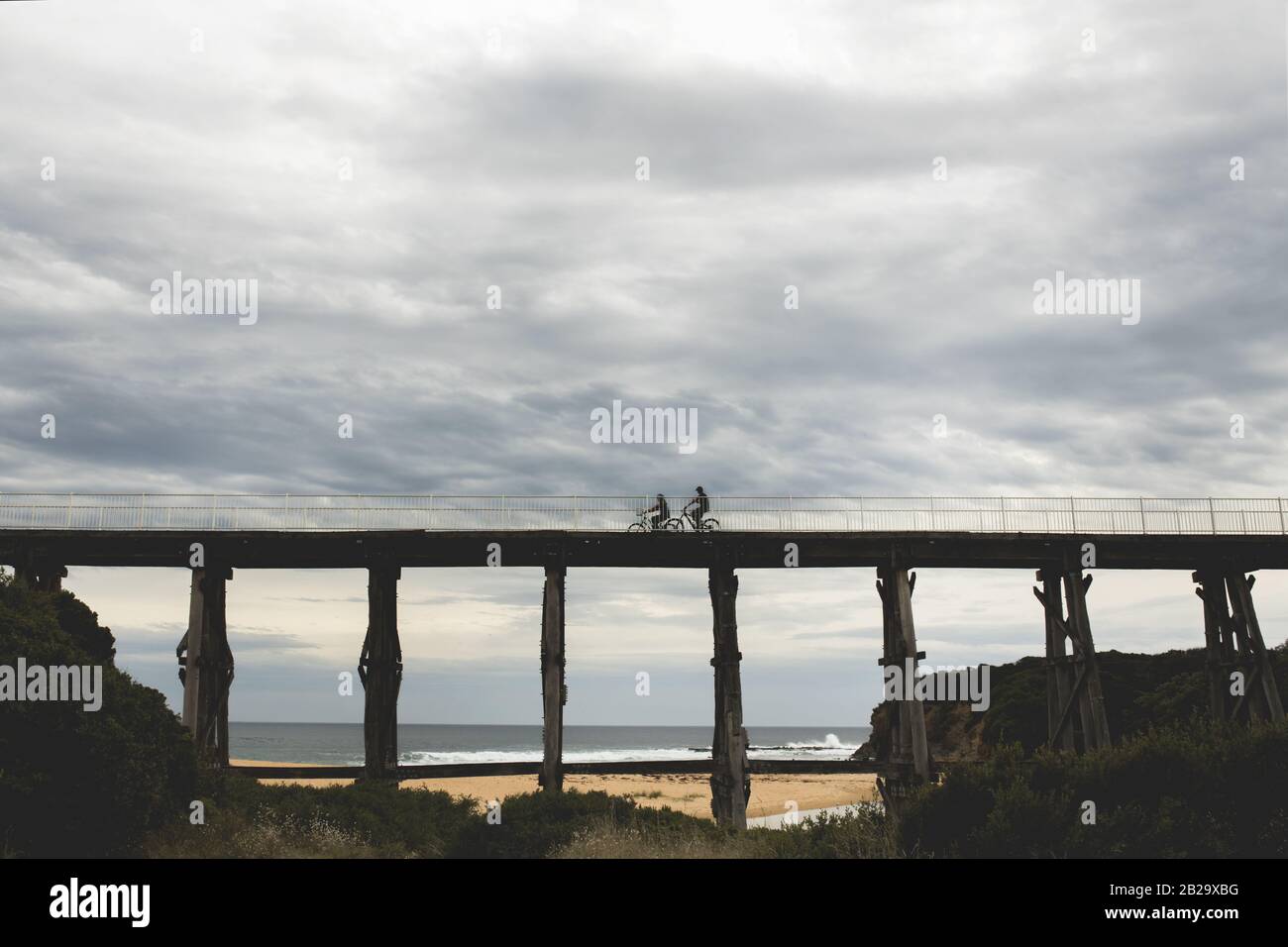 Photos de silhouettes sur le pont de la rivière Kilcunda Bourne Creek Trestle Bridge lors d'une journée de ciel dans le Gippsland Victoria avec la mer en arrière-plan Banque D'Images