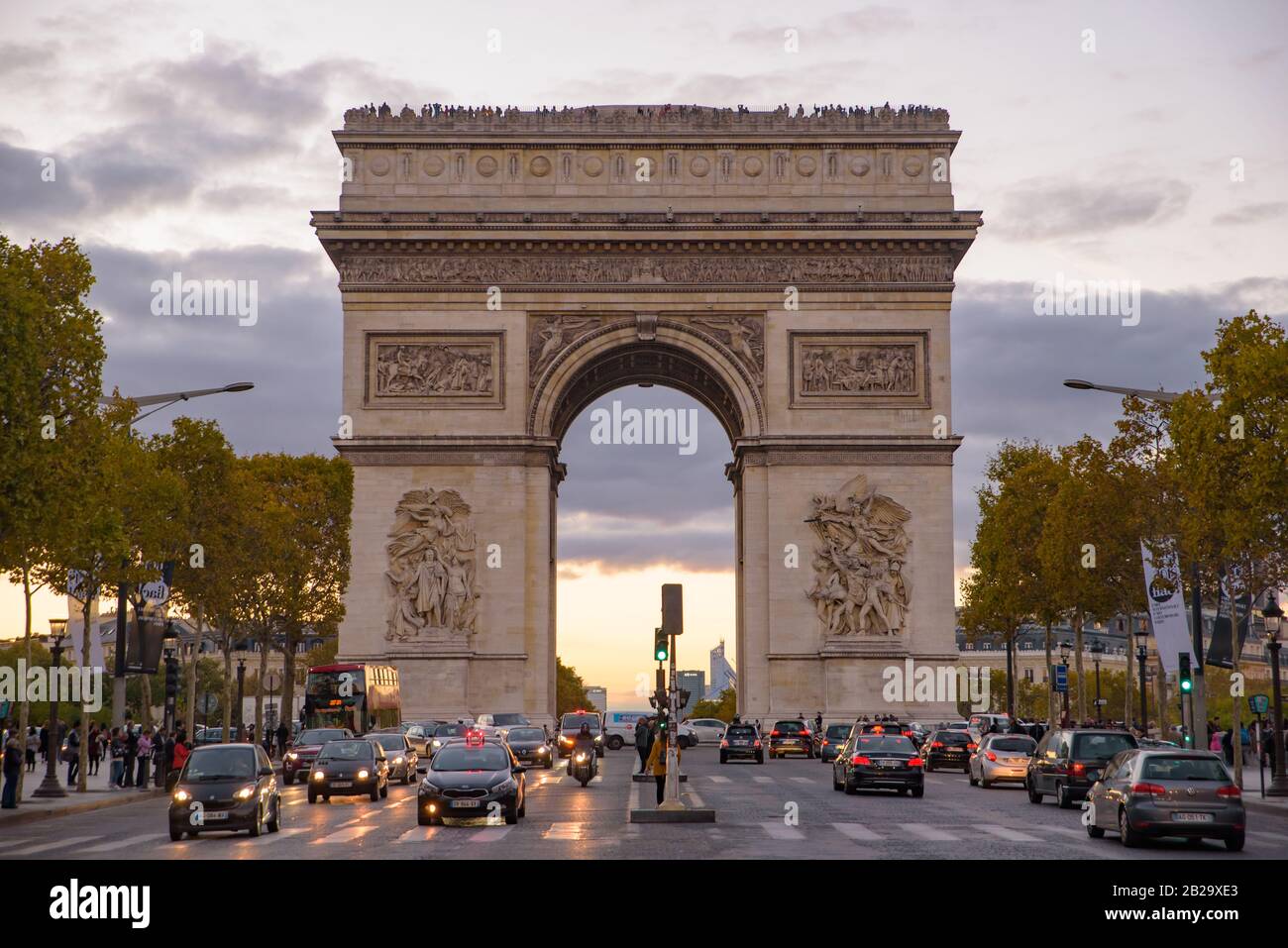 Le trafic au coucher du soleil devant l'Arc de Triomphe, l'un des plus célèbres sites de Paris, France Banque D'Images