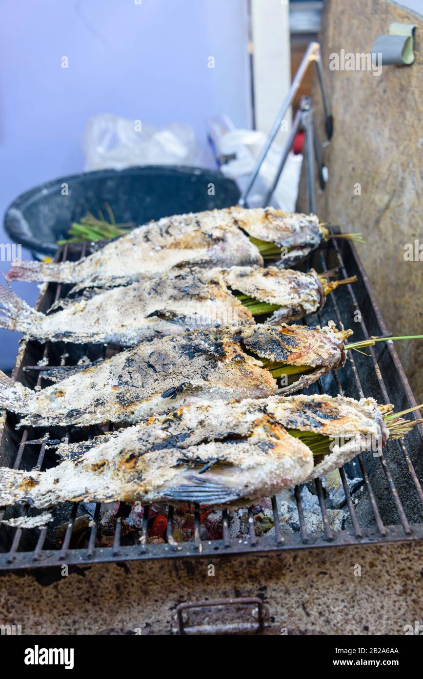 Poisson salé à base de citronnelle cuit sur un barbecue dans un étalage alimentaire de rue, Bangkok, Thaïlande Banque D'Images