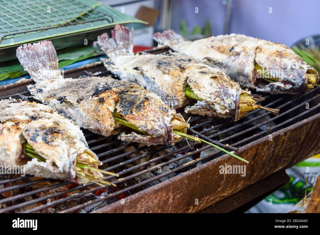 Poisson salé à base de citronnelle cuit sur un barbecue dans un étalage alimentaire de rue, Bangkok, Thaïlande Banque D'Images