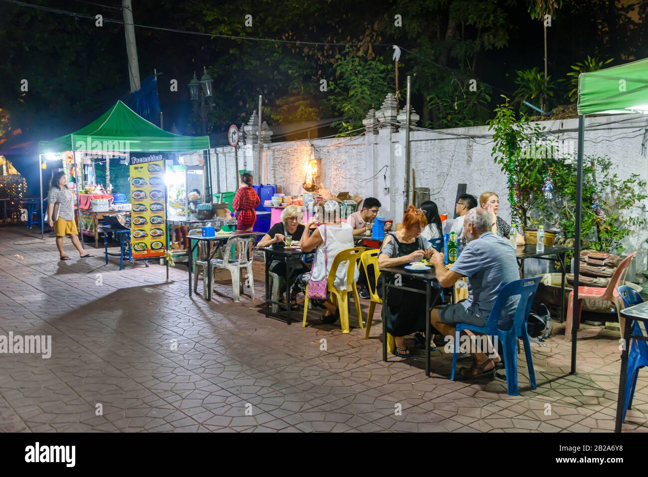 Les gens qui mangent de la nourriture à des tables sur le sentier d'un restaurant de restauration de rue, Bangkok, Thaïlande Banque D'Images