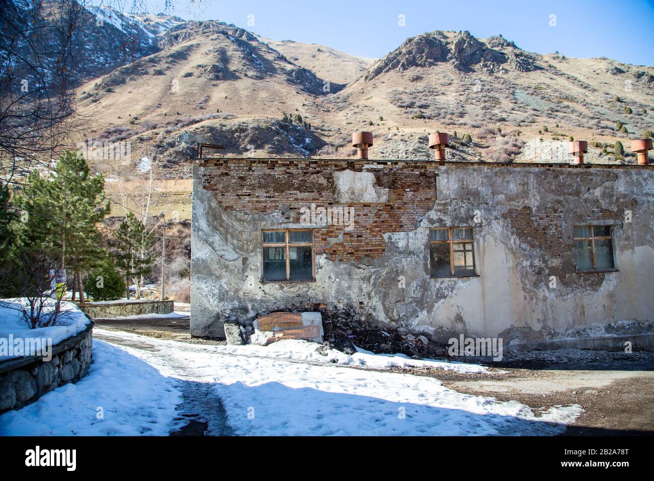 Ancien bâtiment abandonné. Sur fond de montagnes d'hiver. Paysage sombre. Banque D'Images