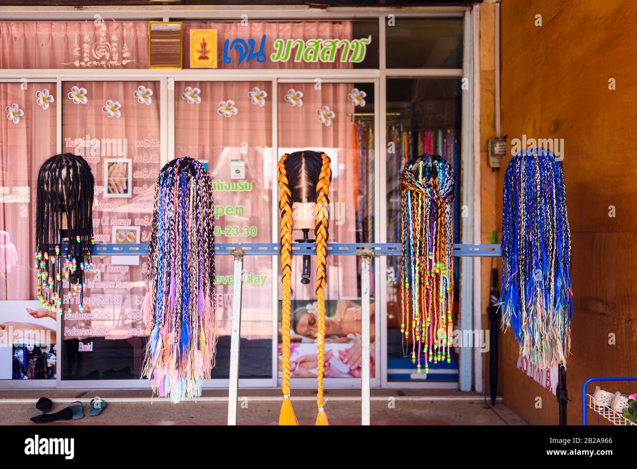 Cinq têtes à l'extérieur d'un salon de coiffure montrant des tresses de cheveux, Thaïlande. Banque D'Images Cinq têtes à l'extérieur d'un salon de coiffure montrant des tresses de cheveux, Thaïlande. Banque D'Images