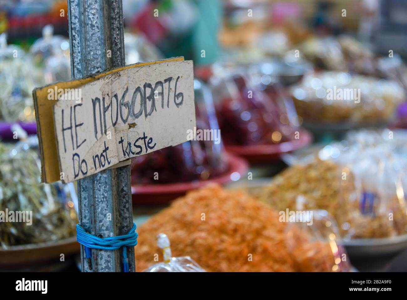 Signe disant 'ne pas goûter' en thaïlandais et en anglais dans un marché alimentaire en Thaïlande Banque D'Images