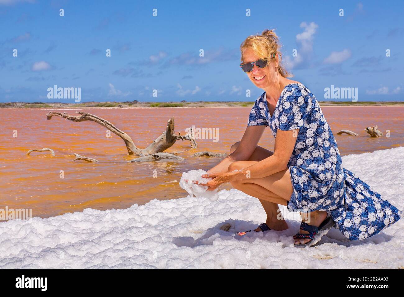 La femme néerlandaise détient de la mousse blanche près du lac de sel d'orange sur Bonaire Banque D'Images