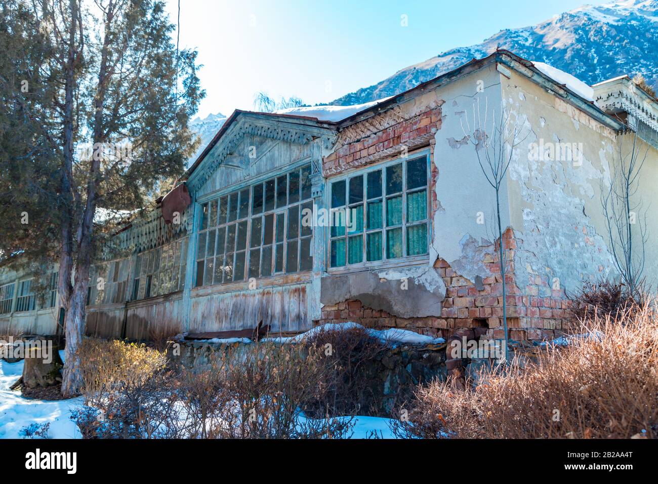 Ancien bâtiment abandonné. Sur fond de montagnes d'hiver. Paysage sombre. Banque D'Images