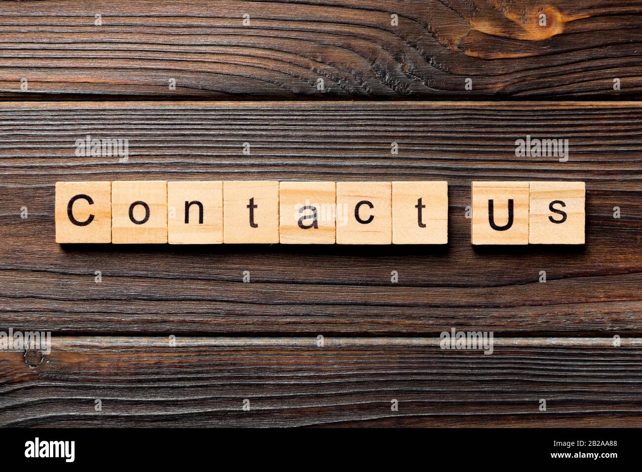 Contactez-nous mot écrit sur une cale en bois. Contactez-nous texte sur table en bois pour votre conception, concept. Banque D'Images