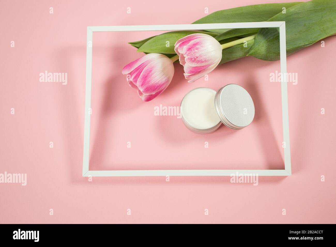 Accessoires de spa sur le fond de wodden avec quelques tulipes et crème faciale Banque D'Images