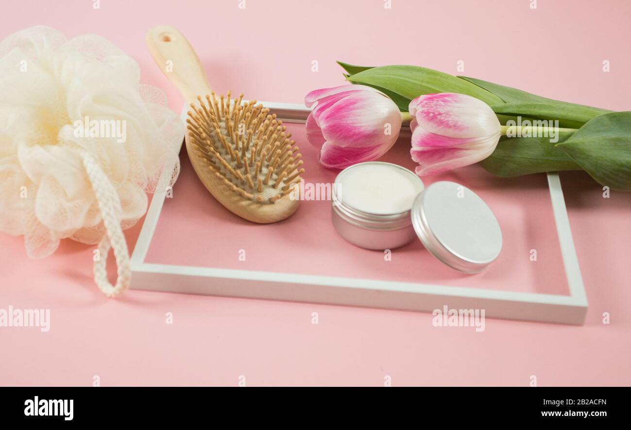 Accessoires de spa sur le fond de wodden avec quelques tulipes et crème faciale Banque D'Images