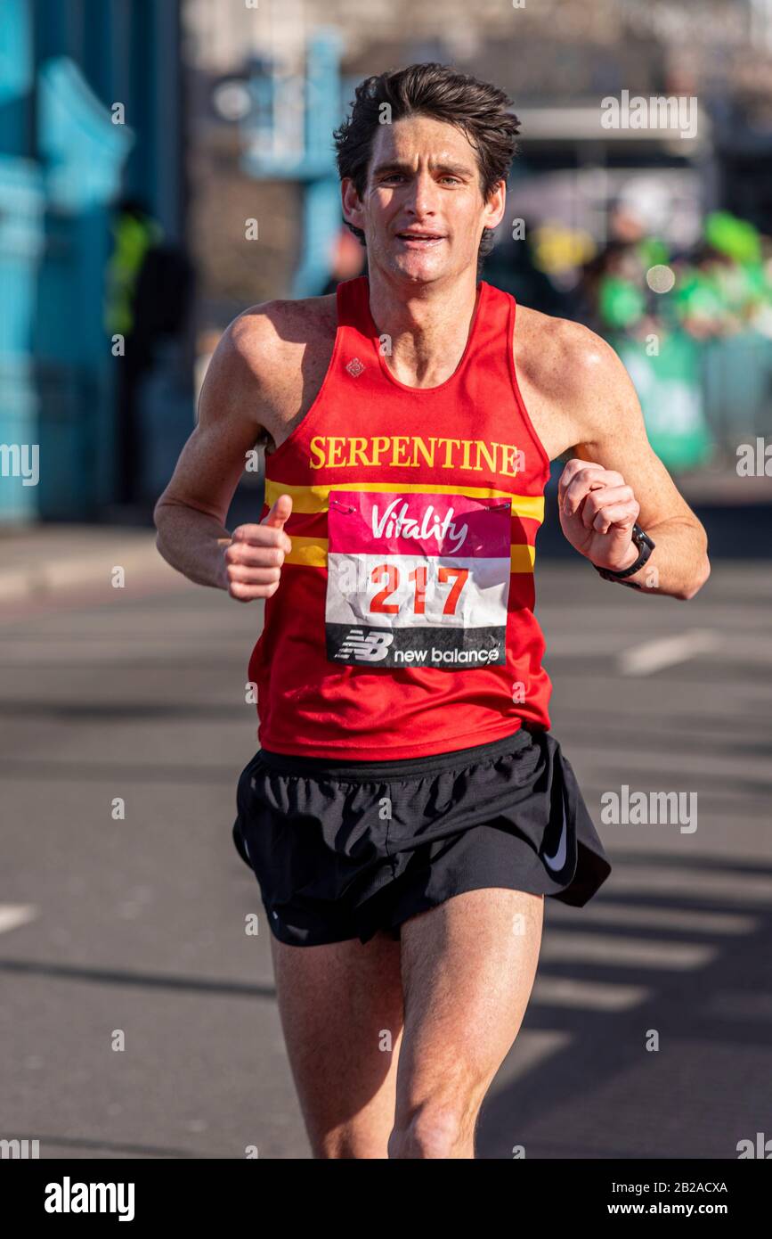 Andy Greenleaf course dans le Vitality Big Half marathon traversant Tower Bridge, Londres, Royaume-Uni. Coureur de club avec club de course à pied Serpentine Banque D'Images