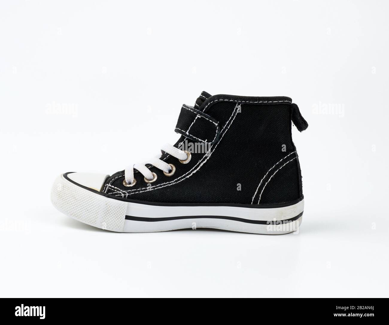 sneaker en tissu noir avec lacets à lacets blancs sur fond blanc, chaussures  se tiennent sur le côté Photo Stock - Alamy