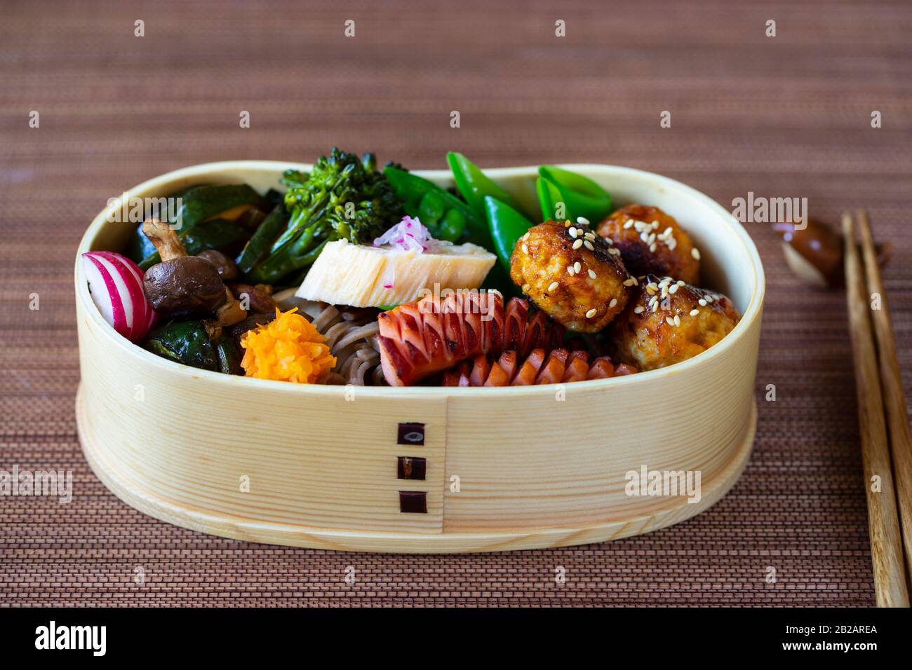 Boîte à bento japonaise avec boulettes de viande, saucisses et légumes Banque D'Images