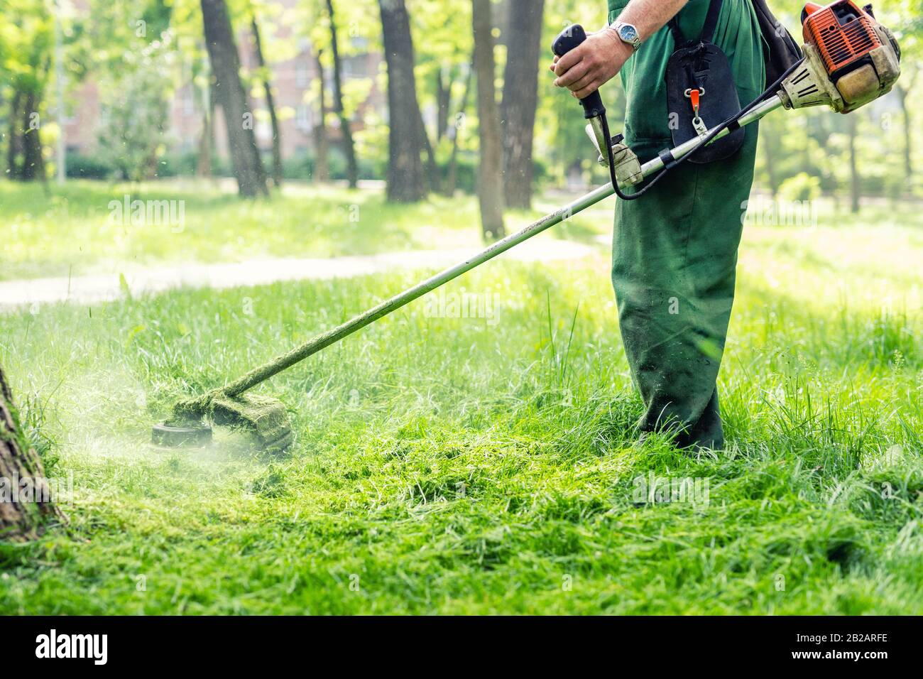 Travailleur fauchant l'herbe haute avec tondeuse à gazon électrique ou  essence dans le parc urbain ou l'arrière-cour. Outils et équipements de  jardinage. Processus de tonte de la pelouse Photo Stock - Alamy
