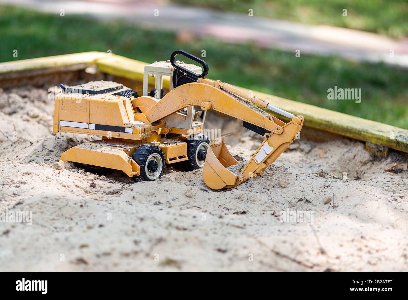 Jouet de pelle hydraulique jaune dans un bac à sable en bois sur le  chantier. Concept de jouets pour garçon Photo Stock - Alamy