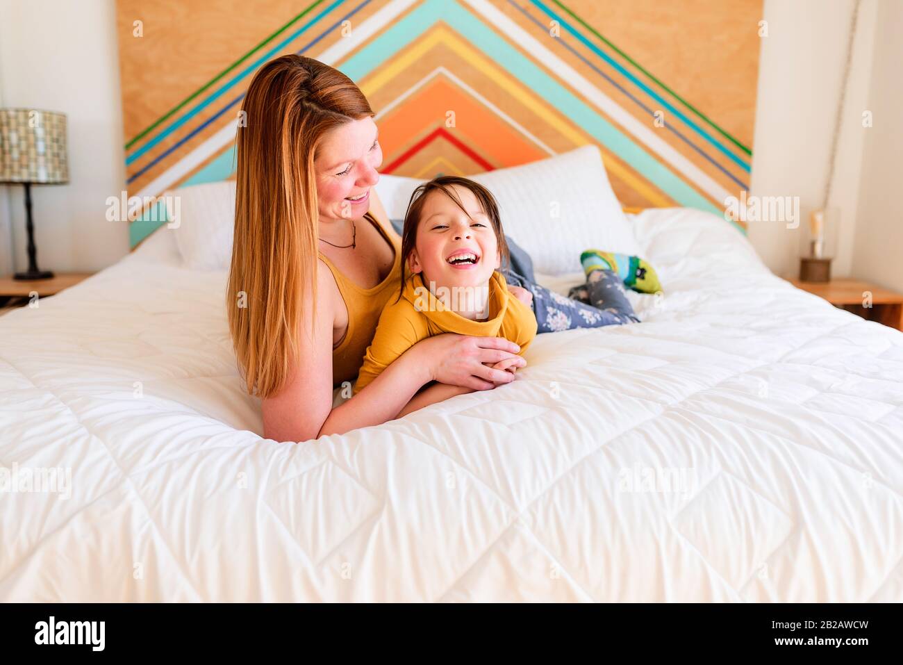 Portrait d'une mère et d'une fille posée sur un lit parlant Banque D'Images