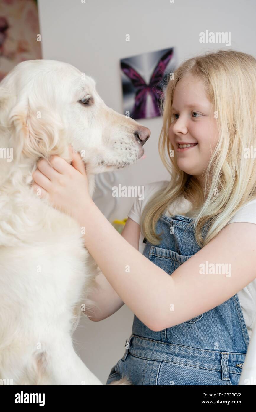 soins et amour pour les animaux de compagnie. jeune fille dans la maison hople avec un grand chien doré de retriever Banque D'Images