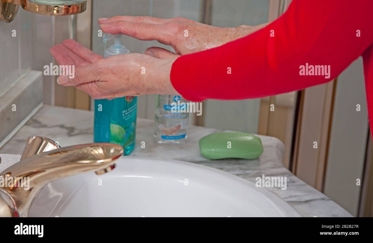 Première affaire de coronavirus confirmée en Écosse. 2 mars 2020. Pour éviter de capturer et de répandre le virus, il est conseillé au public de se laver les mains fréquemment avec du savon et de l'eau ou d'utiliser un gel aseptisant. Photo femme plus âgée se laver les mains dans l'évier de salle de douche. Banque D'Images