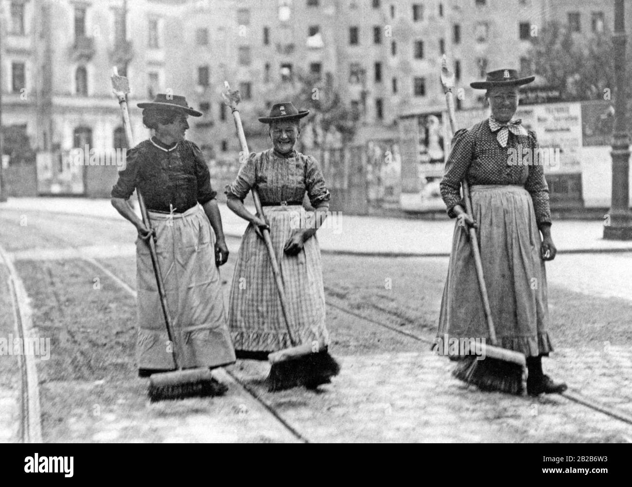 Les femmes balaient les rues de Munich avec des balais. Banque D'Images