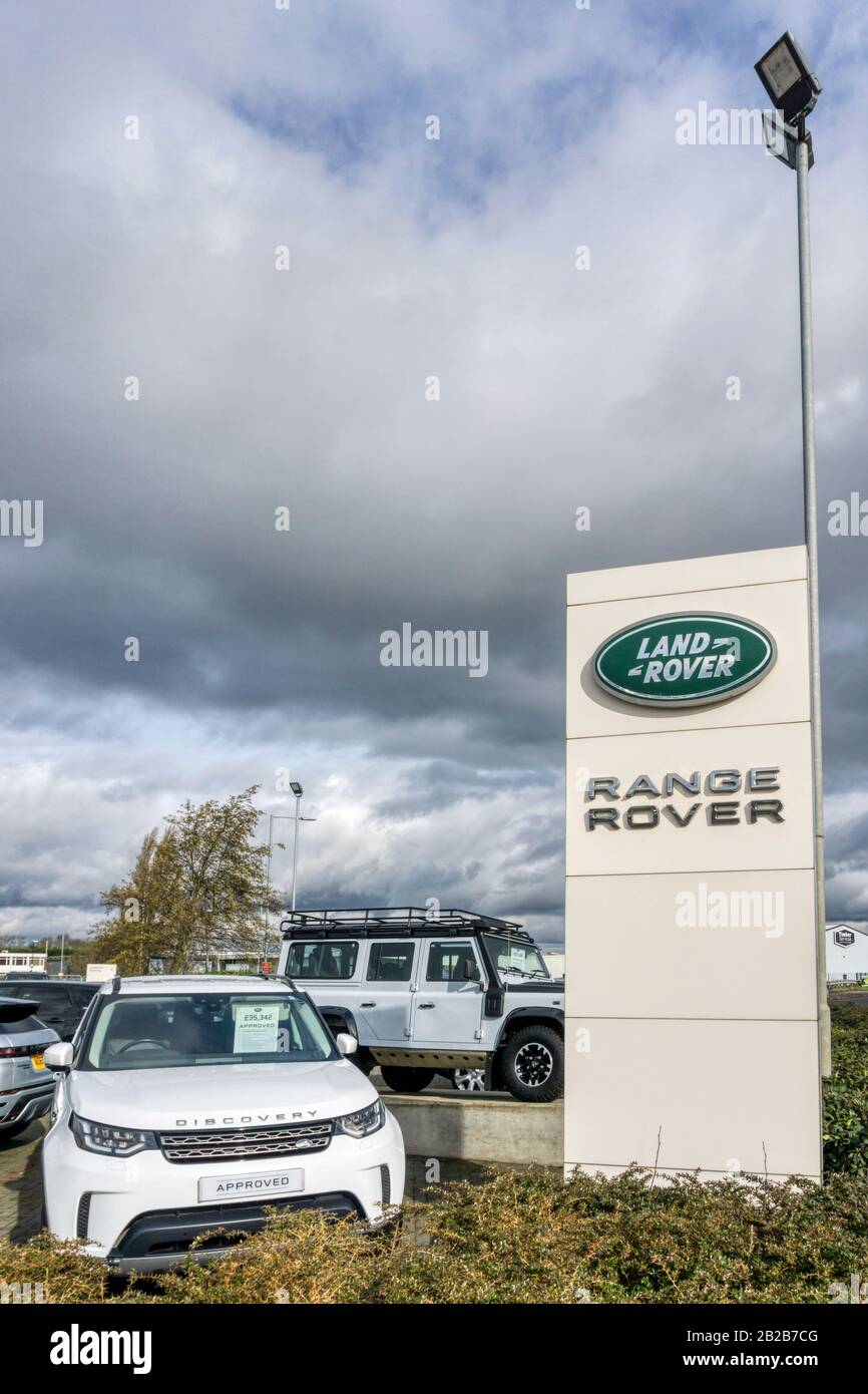 Un Land Rover Discovery, avec Defender en arrière-plan, sur la piste de la concession Land Rover Range Rover. Banque D'Images