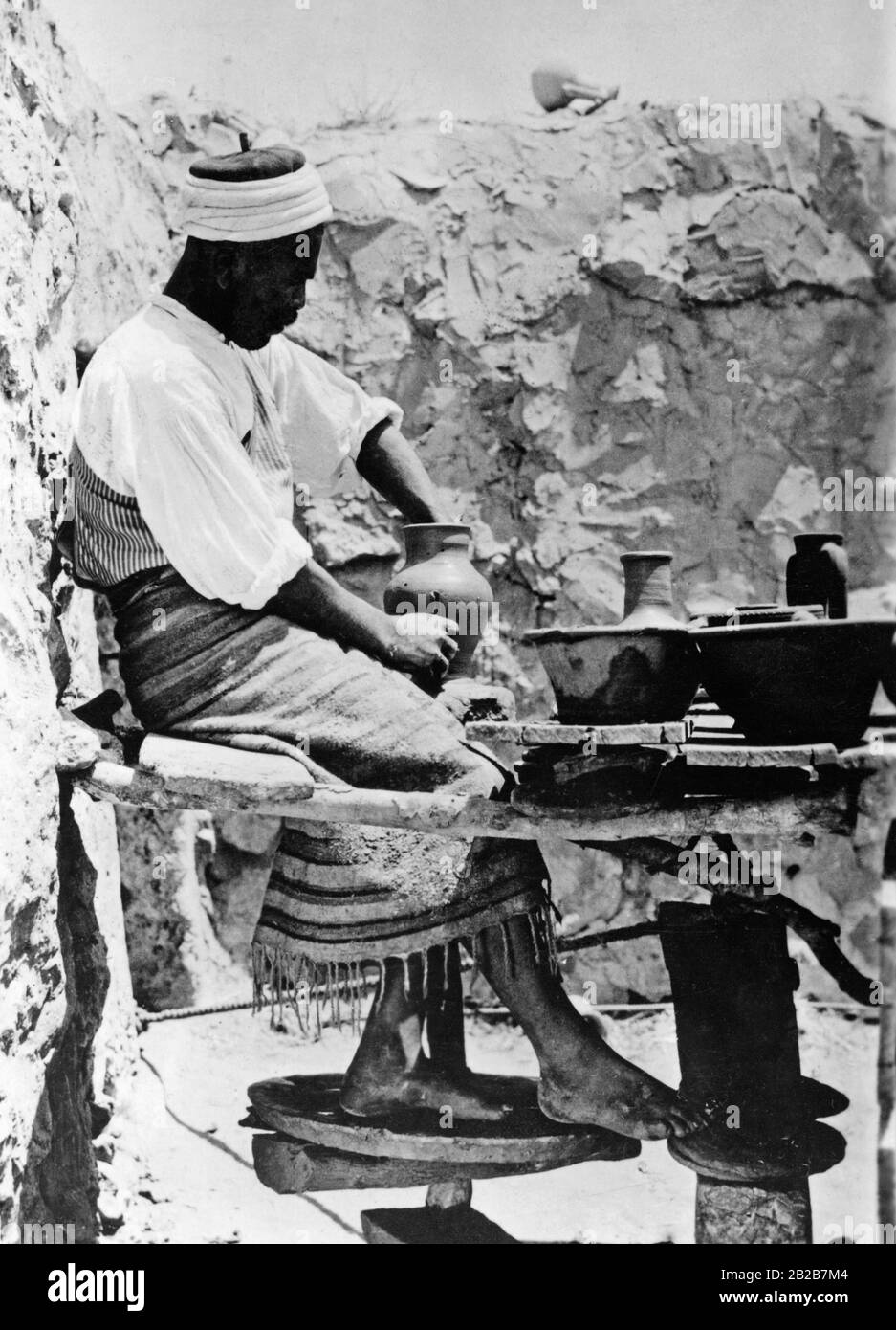Un homme en Tunisie faisant de la poterie. Il régule la vitesse de la platine à l'aide de la molette. Banque D'Images