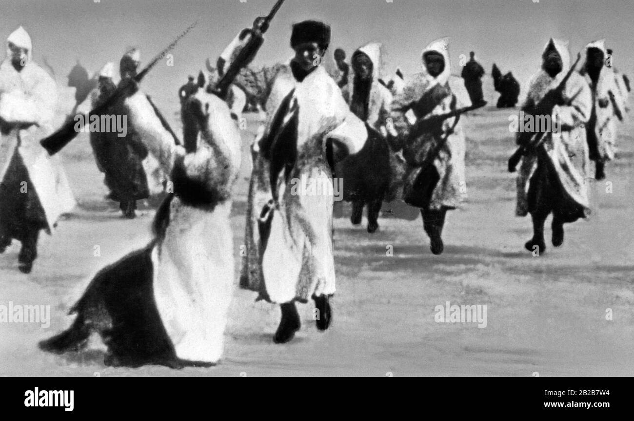 L'infanterie de l'Armée rouge s'attaquant sur la glace du golfe de Finlande, portant des costumes de camouflage blancs, lors de leur deuxième attaque contre la garnison de Kronstadt sur l'île Kotlin. Au premier plan se trouve un soldat de l'Armée rouge qui a été abattu et tombe. Banque D'Images