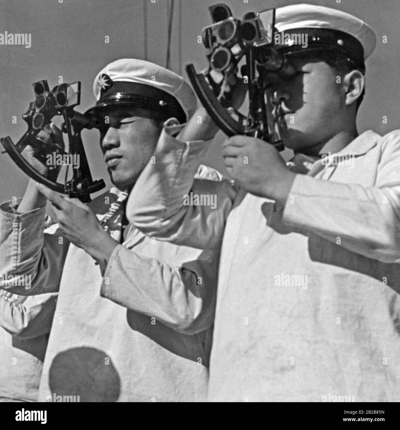 Deux cadets de l'Ecole navale de Tokyo pratiquent la navigation avec l'aide de sextants à bord de leur navire d'entraînement Taisei Maru lors d'une croisière dans le Pacifique Sud. (Photo non datée, c années 1930) Banque D'Images