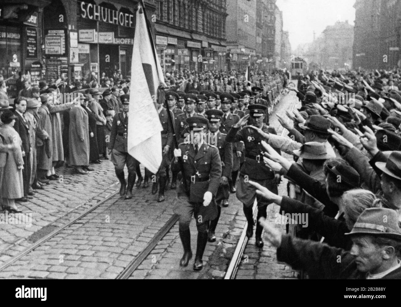 Un groupe d'une organisation japonaise de jeunes marche à Berlin. Ils sont accueillis avec le salut nazi par les gens qui bordent la rue à gauche et à droite. Banque D'Images