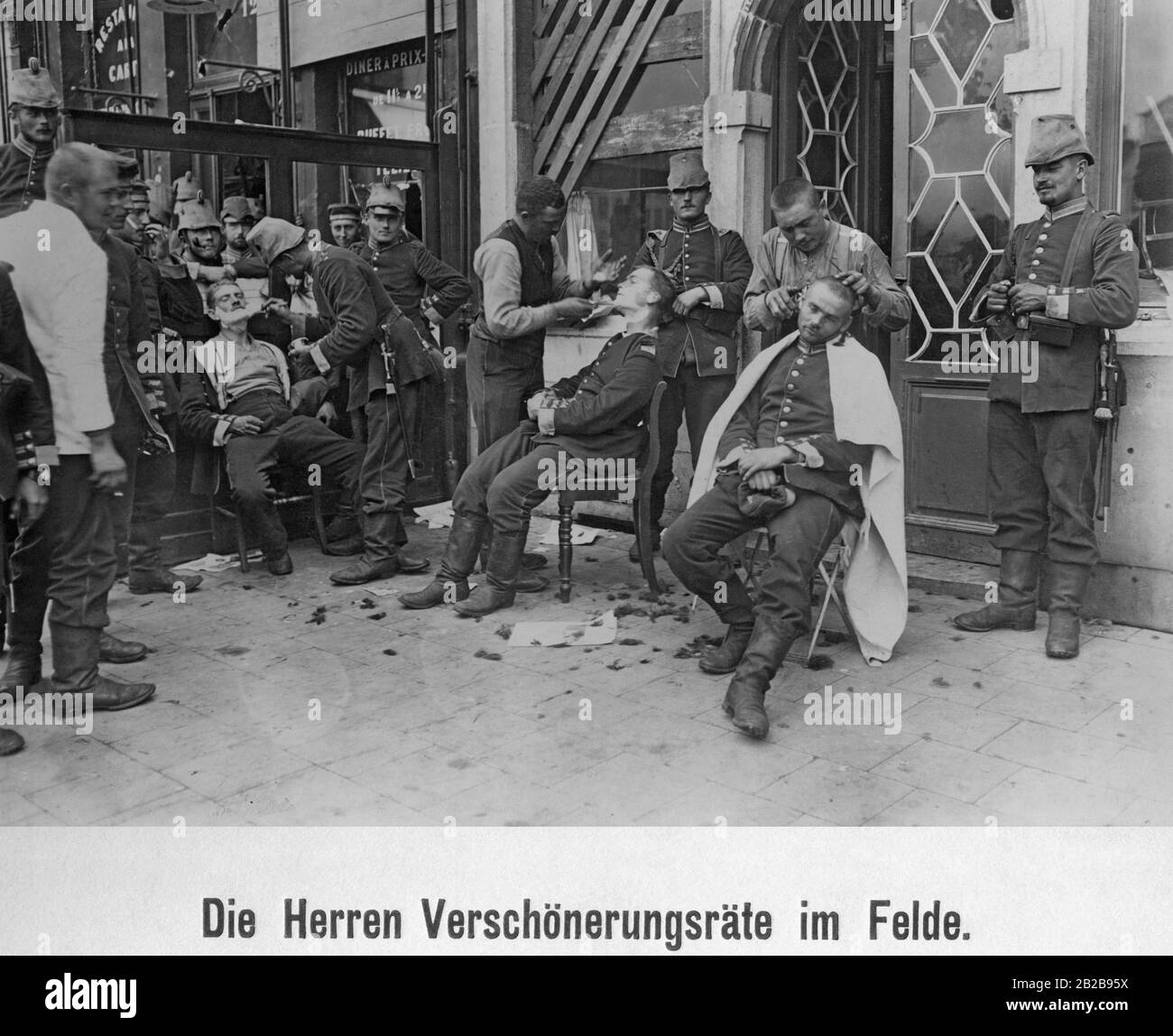 Les soldats sur le devant obtiennent leur coupe de cheveux et leurs barbes rasés. Banque D'Images