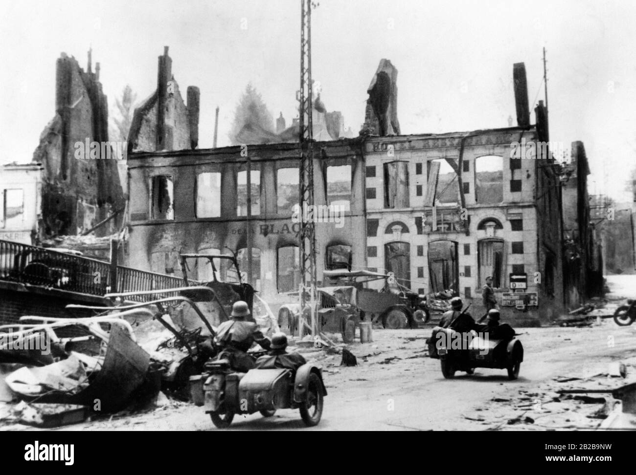 Troupes motorisées avançant dans une ville française détruite. En arrière-plan se trouve un bâtiment détruit au cours de la seconde Guerre mondiale. Banque D'Images