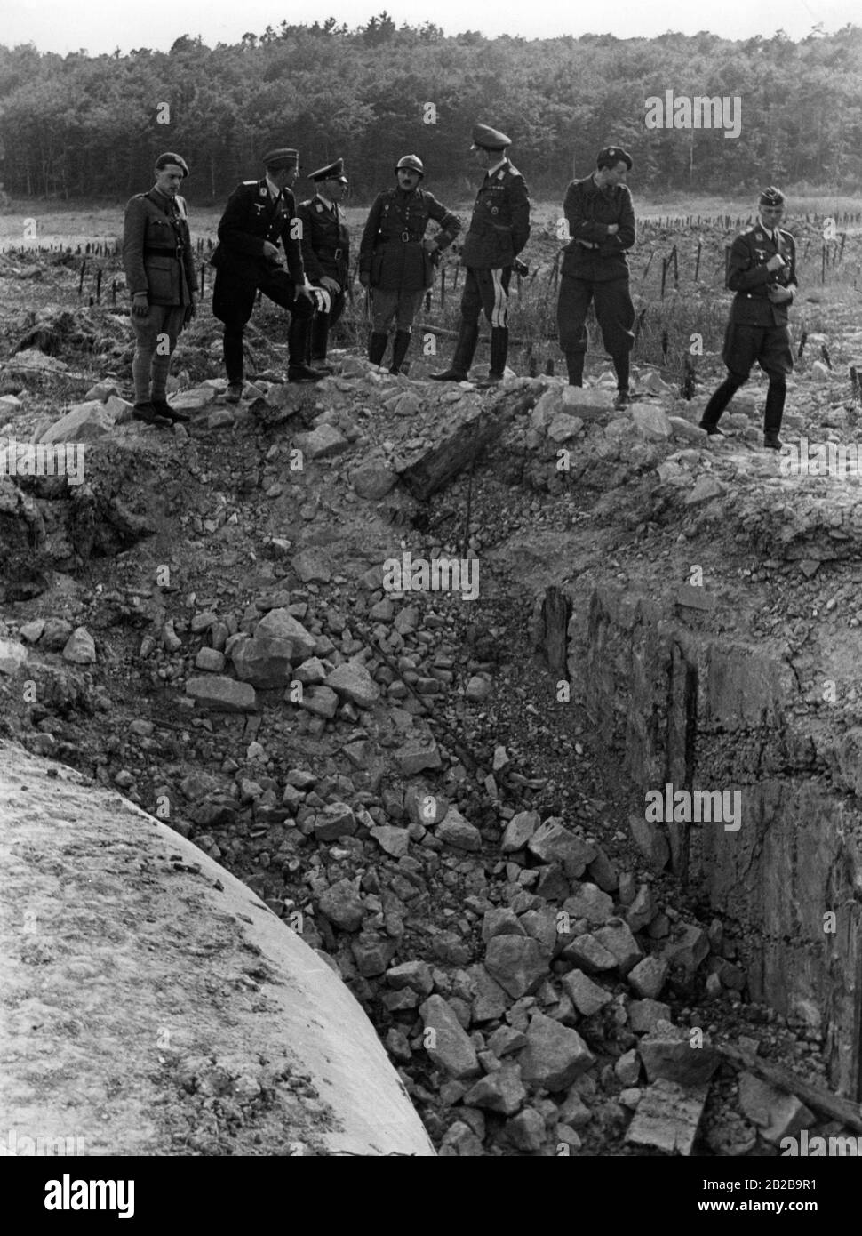 Le capitaine français Emy (au milieu) avec d'autres officiers français et un groupe d'officiers allemands de la Luftwaffe inspectant les dommages causés par une attaque Stuka sur les fortifications de la ligne Maginot. Sur sa gauche, le général allemand Zander. Banque D'Images