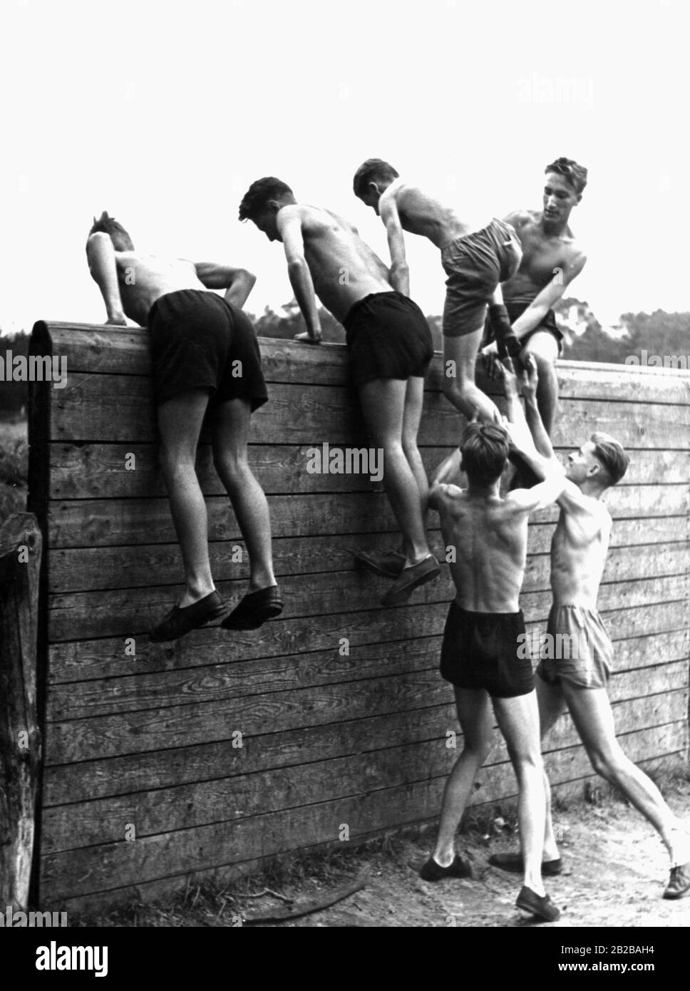 Hitler les membres de la jeunesse grimpent sur un mur lors d'un exercice dans un camp d'entraînement militaire. Banque D'Images