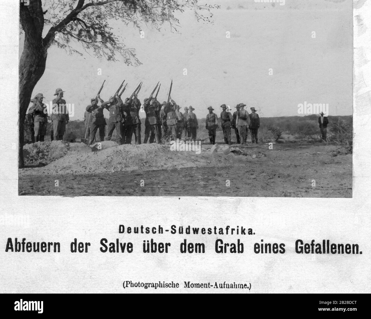 Les soldats allemands incendient le salvo sur la tombe d'un homme mort en Afrique du Sud-Ouest allemande. Ils combattent les tribus insurgées Herero. Banque D'Images