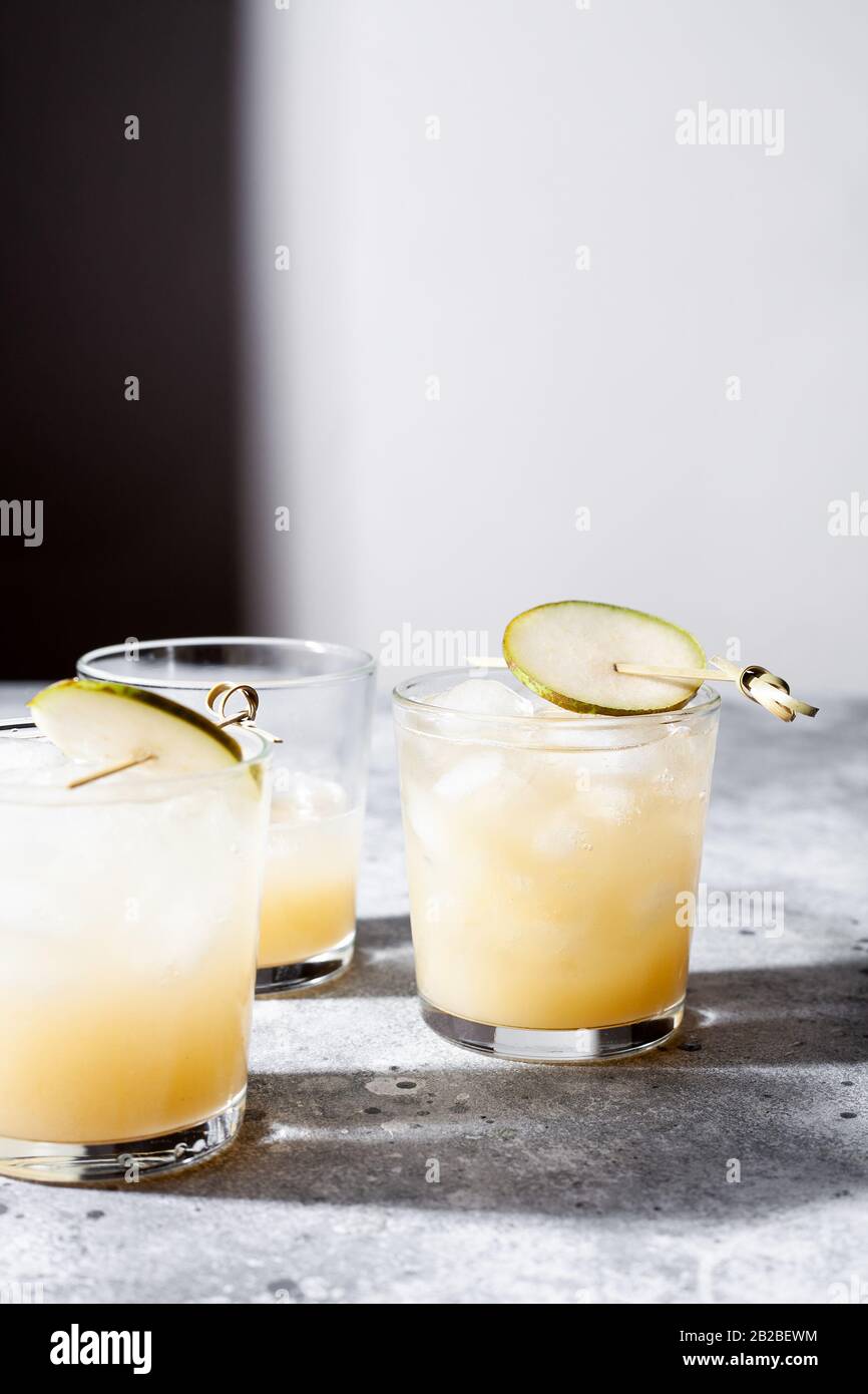 Un petit verre de mocktail ou de cocktail rafraîchissant à base de soda de poire sur fond de béton gris. Boisson estivale sans alcool. Mise au point sélective Banque D'Images