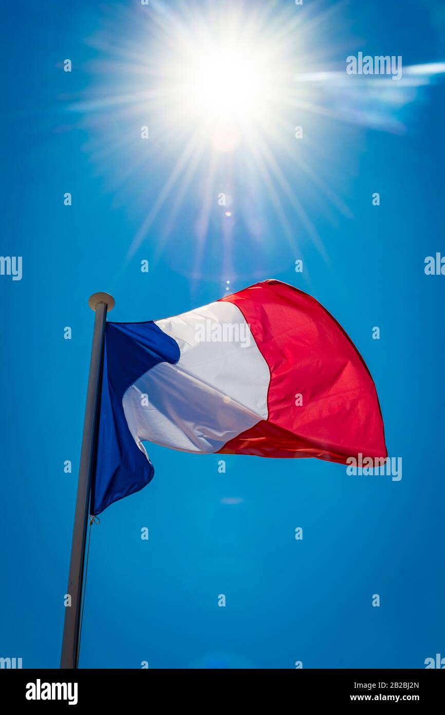Drapeau français rétroéclairé par un soleil éclatant sur la Riviera Banque D'Images