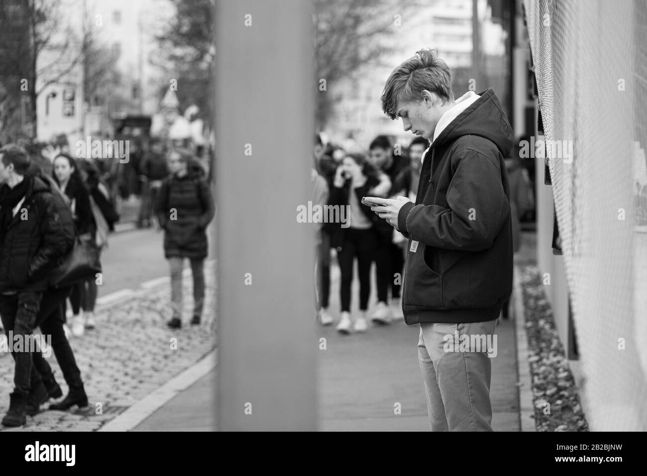 Vienne, Autriche - 11/29/2019: Jeune homme regardant son smartphone pendant une manifestation de grève de la Terre Banque D'Images