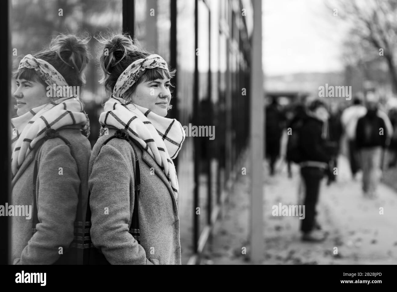 Vienne, Autriche - 11/29/2019: Jeune femme regardant une manifestation de grève de la Terre depuis un trottoir Banque D'Images