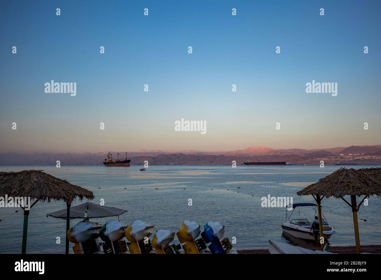 Aqaba, JORDANIE - 31 JANVIER 2020: Très tôt le matin mais les bateaux touristiques attendent des touristes curieux, la plage de la ville. Hiver ciel de vacances clair autour du lever du soleil. golfe de la Mer Rouge, Royaume hachémite de Jordanie Banque D'Images