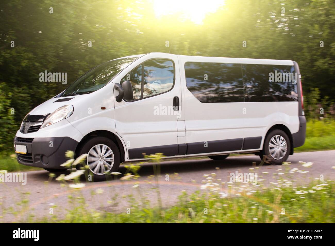 voiture sur une route de campagne, petit bus blanc va sur l'autoroute en soirée Banque D'Images