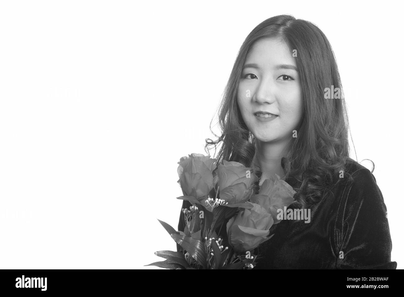 Jeune femme asiatique heureuse tenant des roses rouges prêt pour la Saint-Valentin Banque D'Images