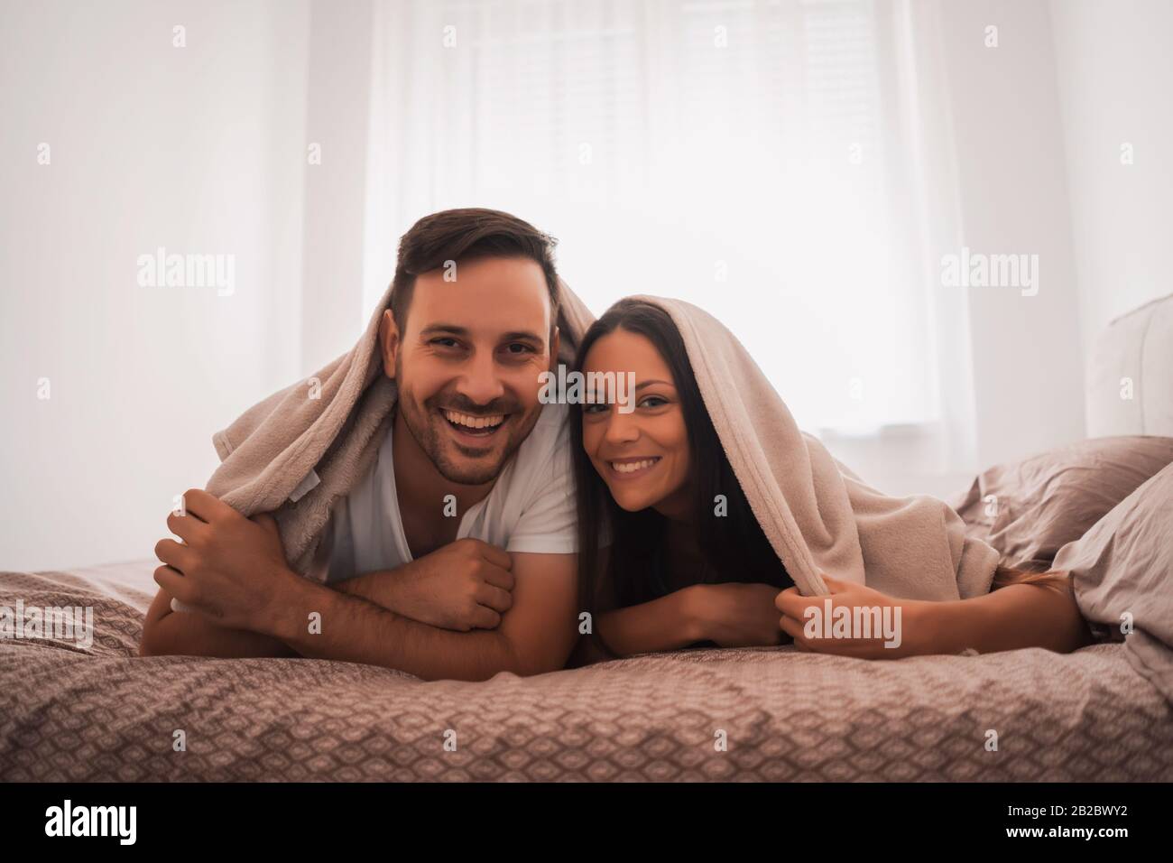 Heureux couple s'amuse au lit. Banque D'Images